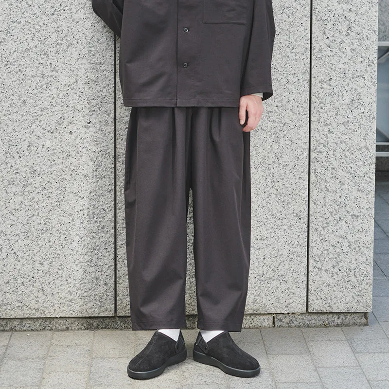 Model wearing wide dark MUJI trousers