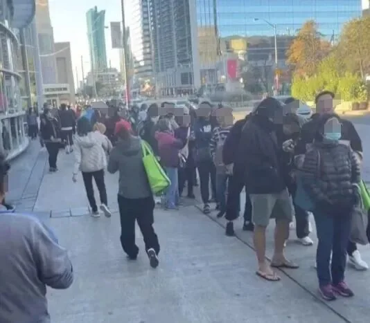 Opening-day shoppers queued on the sidewalk near Empress Walk