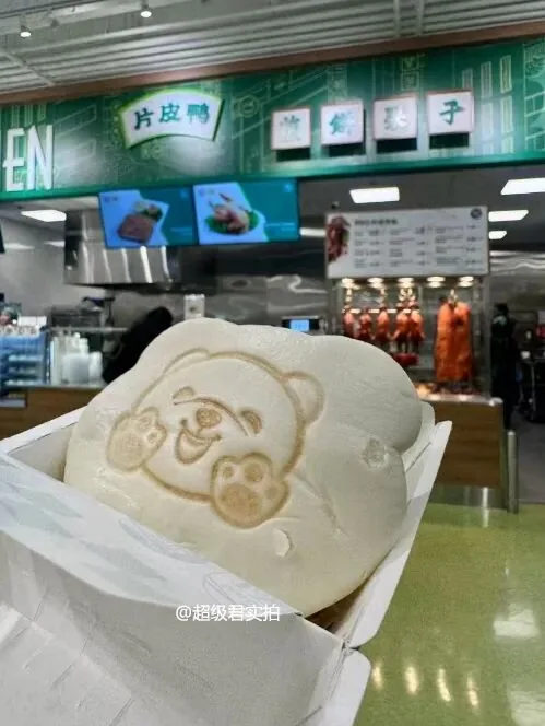 A bear-shaped bun held in front of the North York T&T food counter