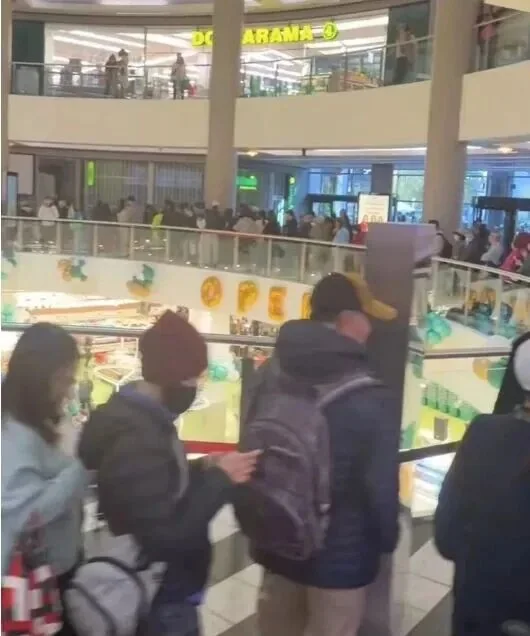 Visitors looking down into the Empress Walk atrium by the escalator
