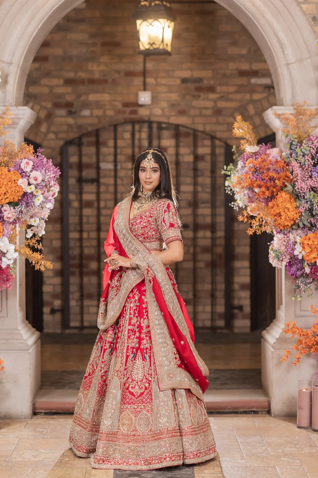 A woman wearing an ornate red formal outfit shared by Chandan Fashion