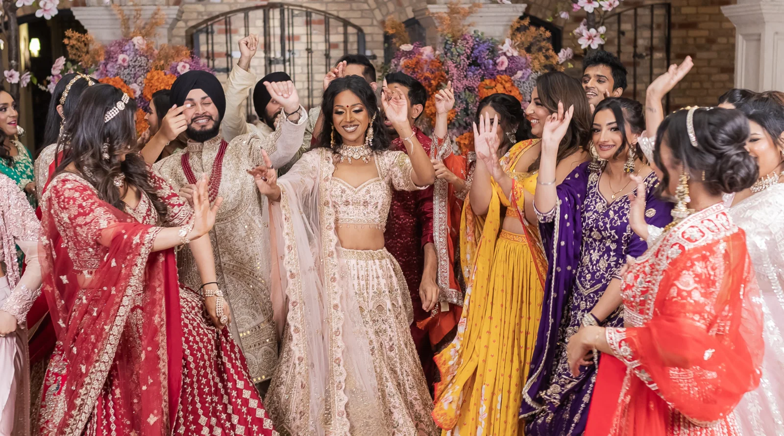 A group dressed in colourful formal South Asian clothing