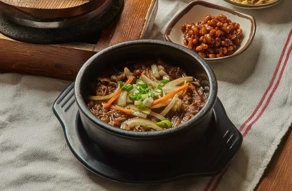 A hot soup bowl with vegetables in Buk Chang Dong Soon Tofu menu photography