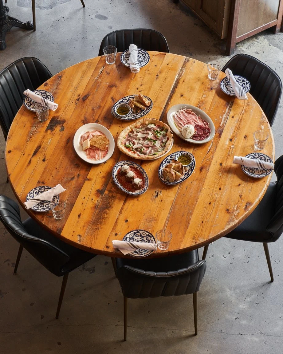 Food plates and wine glasses on a round wooden table