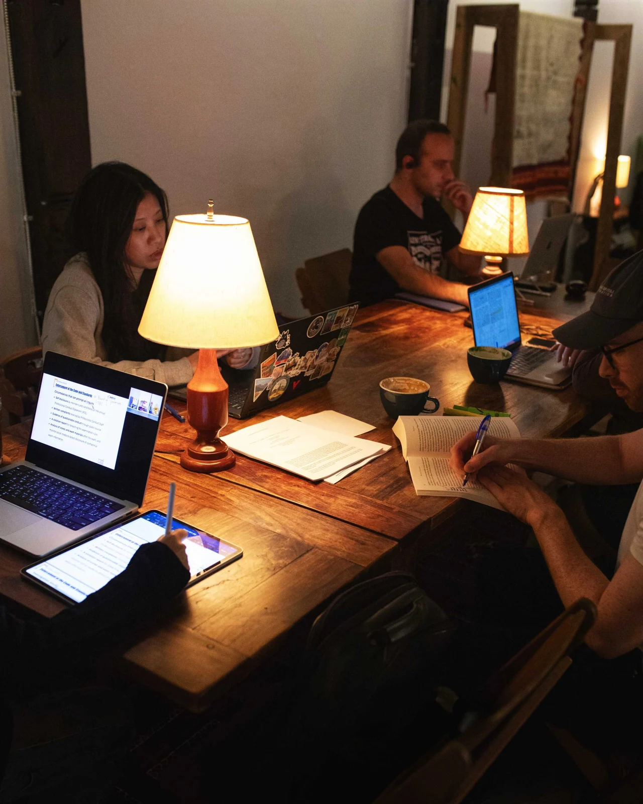 People using laptops at wooden tables inside Nabulu Coffee
