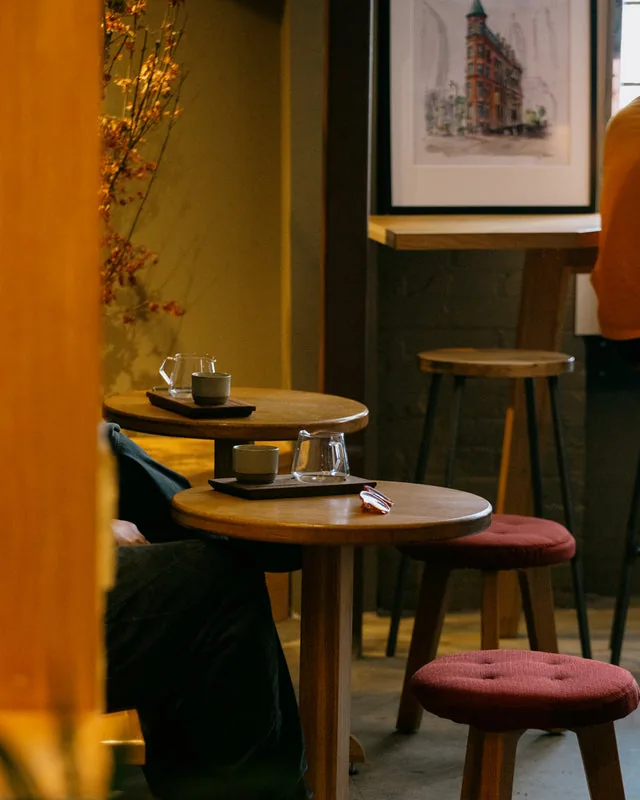 Coffee cups and stools beside a table at Boxcar Social Laneway