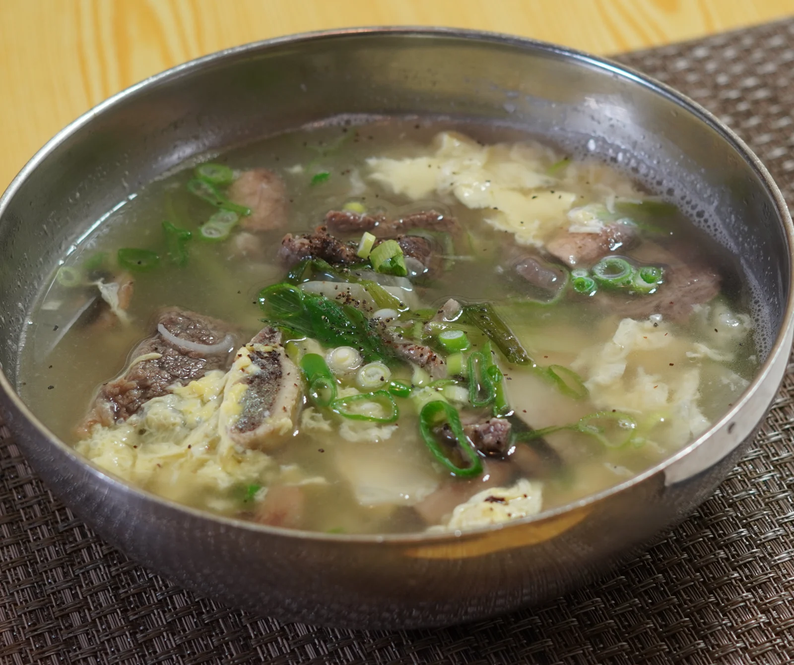 A bowl of clear beef-rib soup in Korean Village’s menu photograph